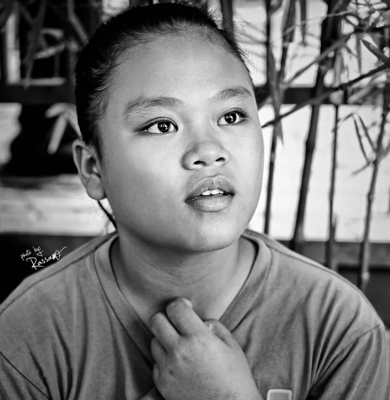 Young woman with her hand at her collar looking to the side, black and white