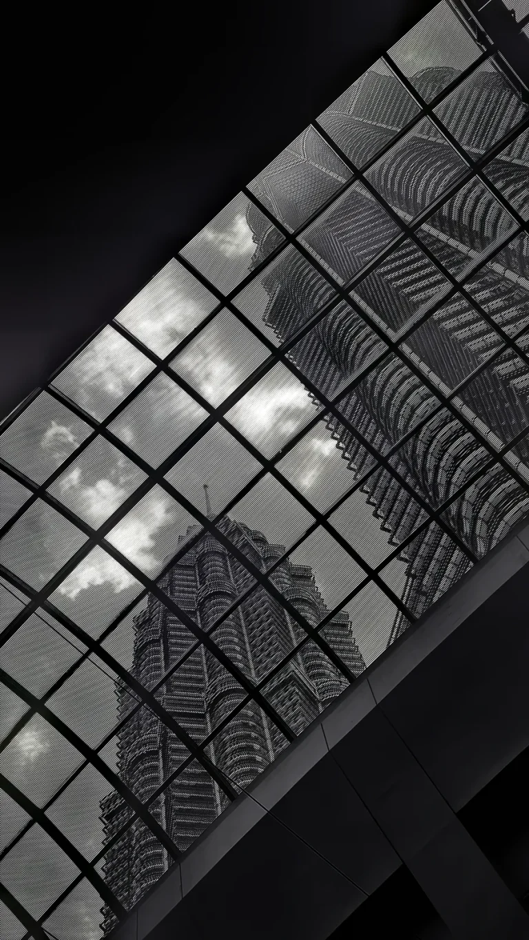 Petronas Twin Towers seen through a diagonal grid of striped glass panels, black and white.