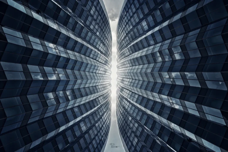 Two mirrored glass towers curving toward a sliver of sky