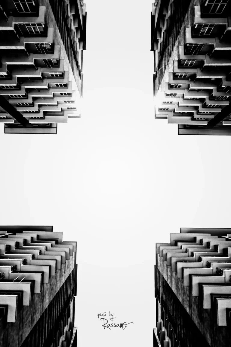 Four apartment towers framing a cross of white sky