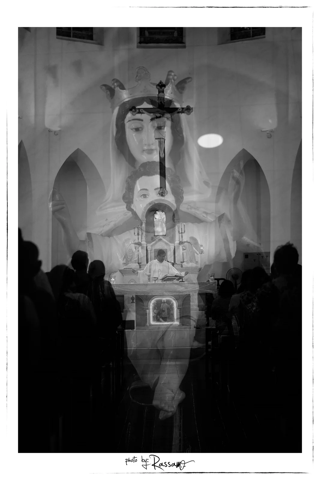 Double exposure of a crowned statue of Mary and Child over the congregation and the altar, black and white